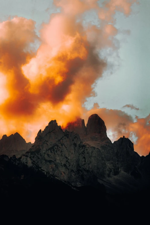 a mountain range with a dark colored cloud filled sky