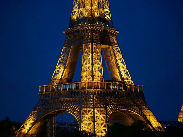 the lighted eiffel tower is shining at night