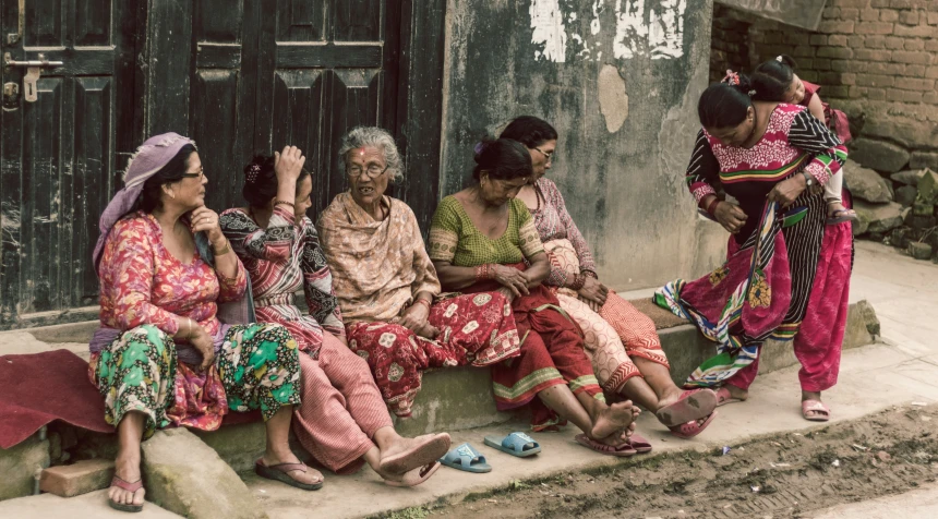 a group of people sit on a ledge near a door