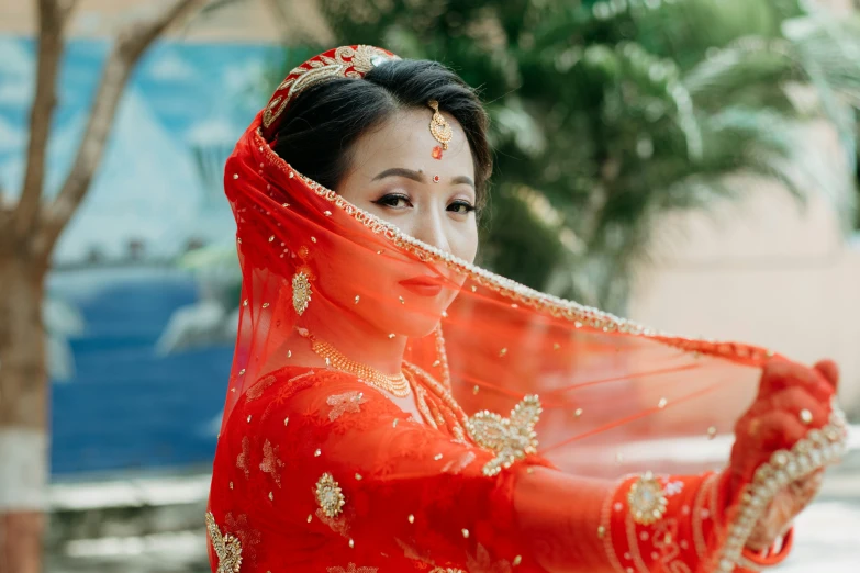 a woman dressed in orange with red veil