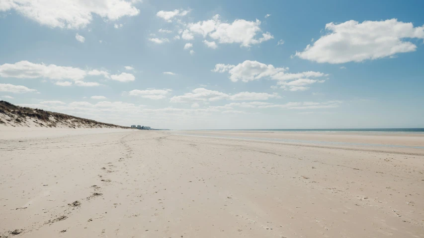 a deserted beach with footprints in the sand