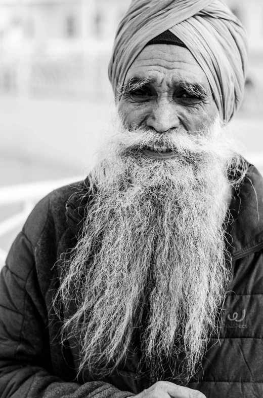 an old man with a long turban standing