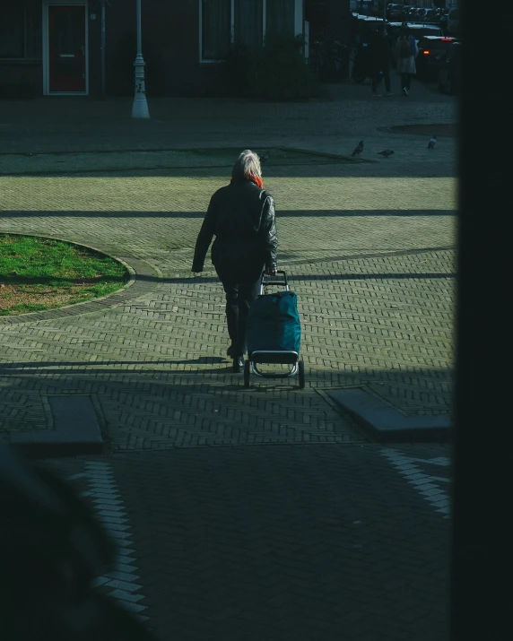 a man pulling a blue suitcase behind his back