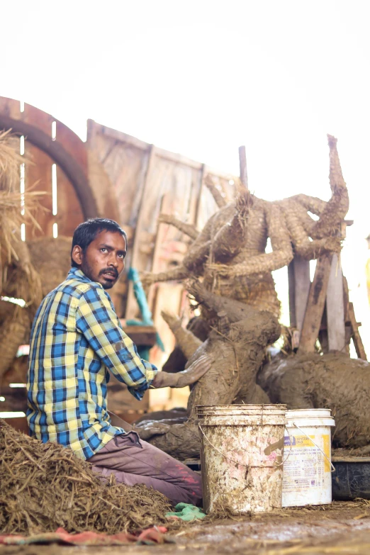 an indian man sitting on the ground with some brown stuff