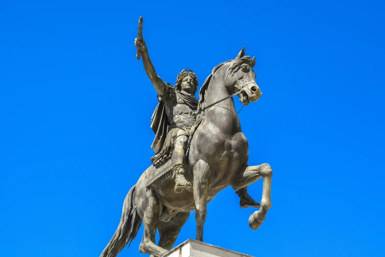 a statue of a man on horseback holding a staff and waving