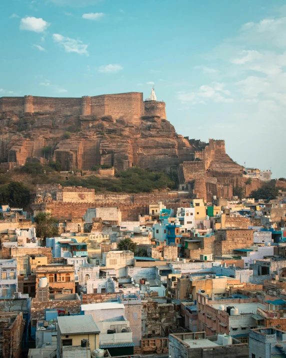 a large mountain sitting above the city in india