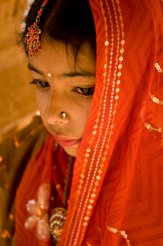 young woman in red sari with a piercing on head