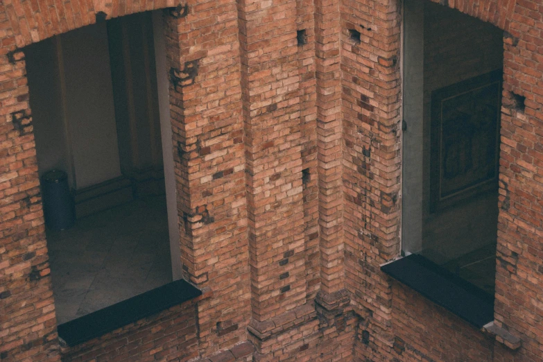 a brick building with two open windows that have small white faces