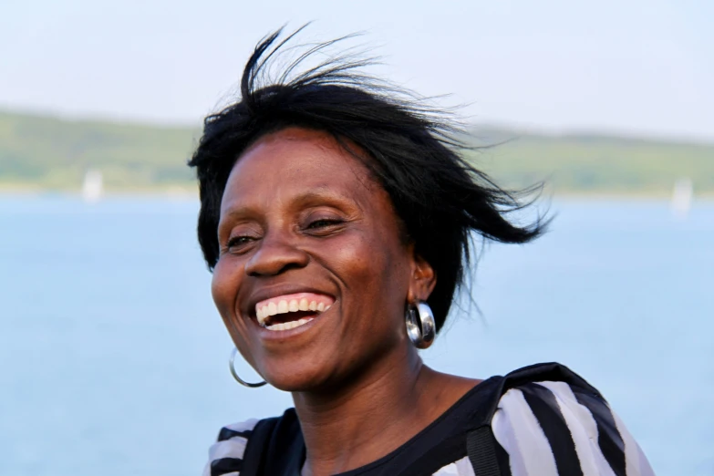 woman with black and white striped shirt smiling on water
