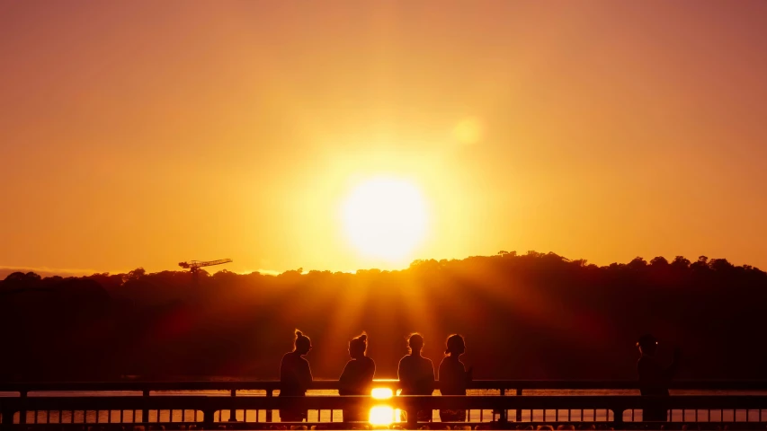 people walk down the walkway as the sun sets