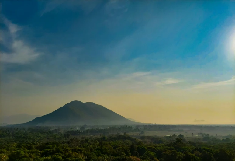 a view of the sun coming over a mountain