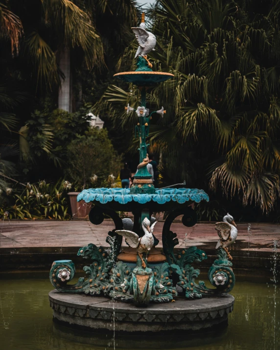 a water fountain surrounded by many birds