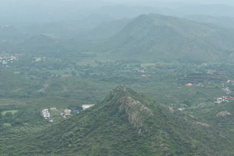 the view of lush mountains and houses from a hill top