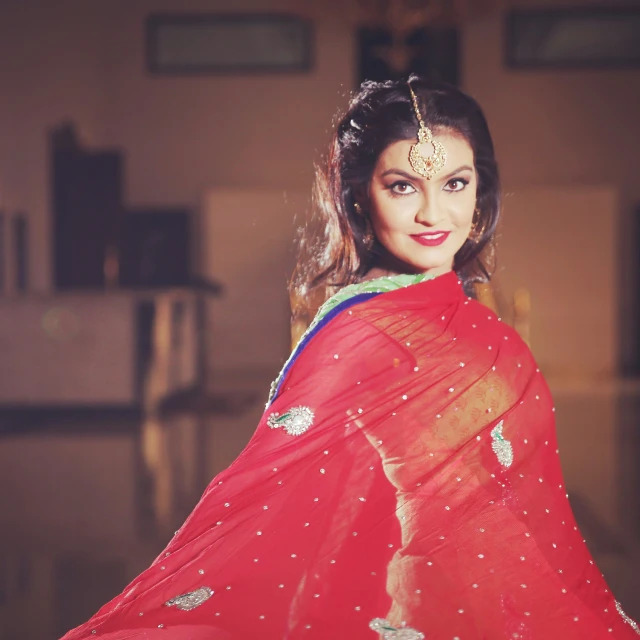 an indian woman in a red sari poses for a picture