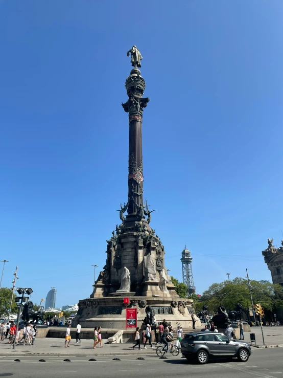 people are gathered around the monument on a sunny day