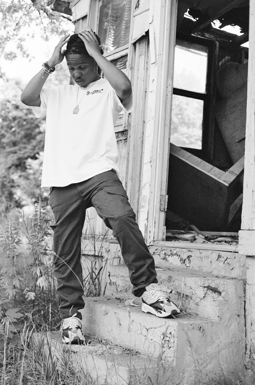 black and white pograph of a young man posing on steps