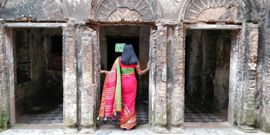 a woman wearing a red and green outfit in a doorway