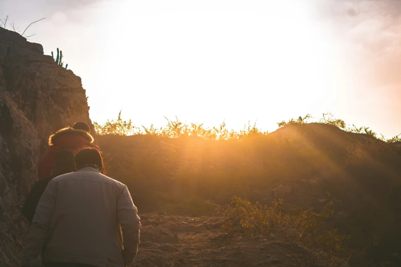 two people on a hike looking at the sun coming up