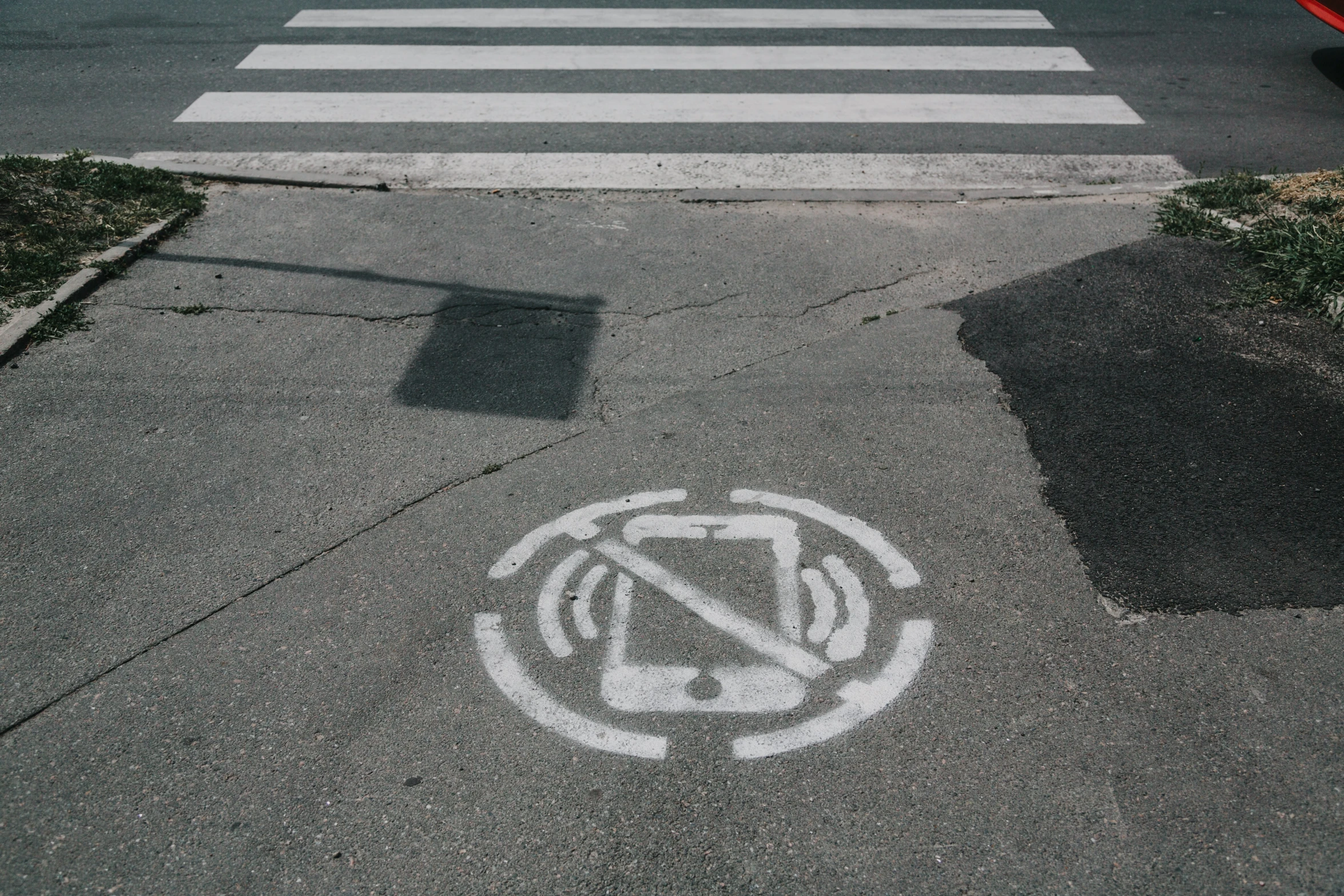 a crosswalk has graffiti in the middle of it