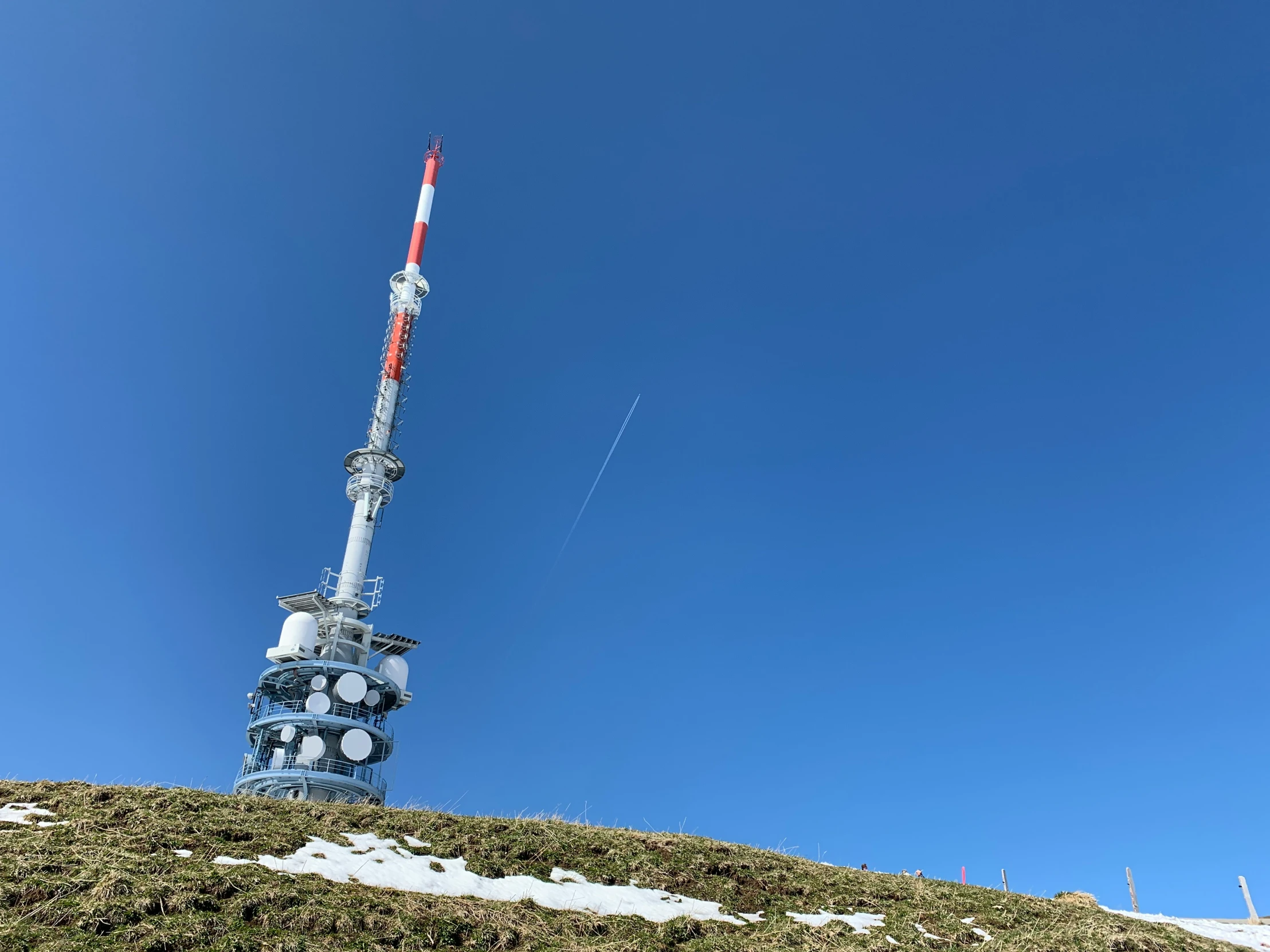 the tower is made of concrete with a red and white top