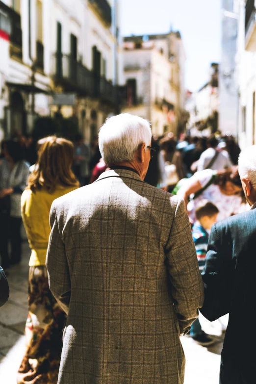 two people walking on the street one in a suit and the other in a yellow jacket