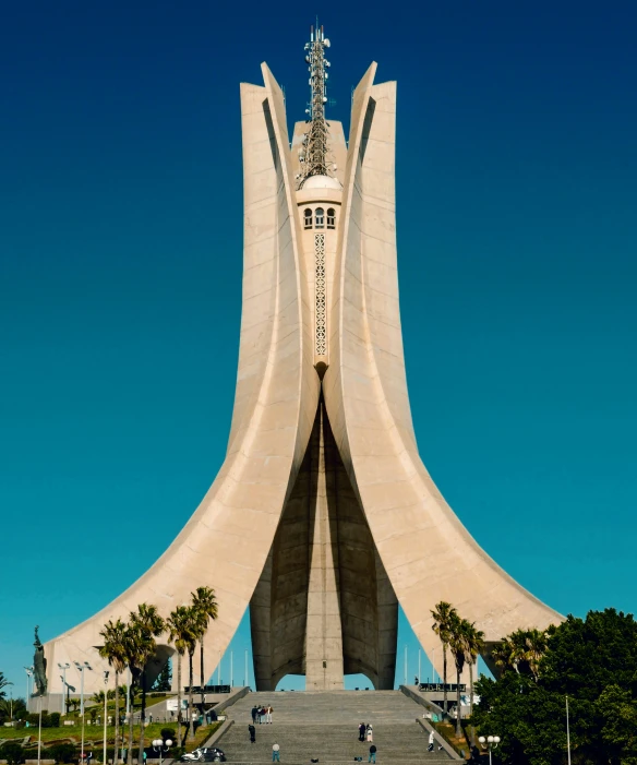 an arch shaped building near trees and blue sky