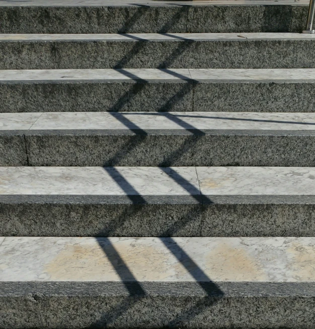 two steps lead to a parking lot with a bench