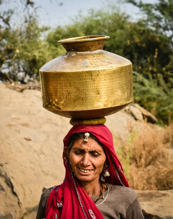 a lady is holding a large tray on her head