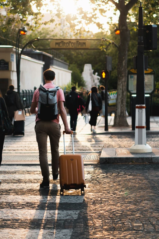 a man carrying his luggage along a street