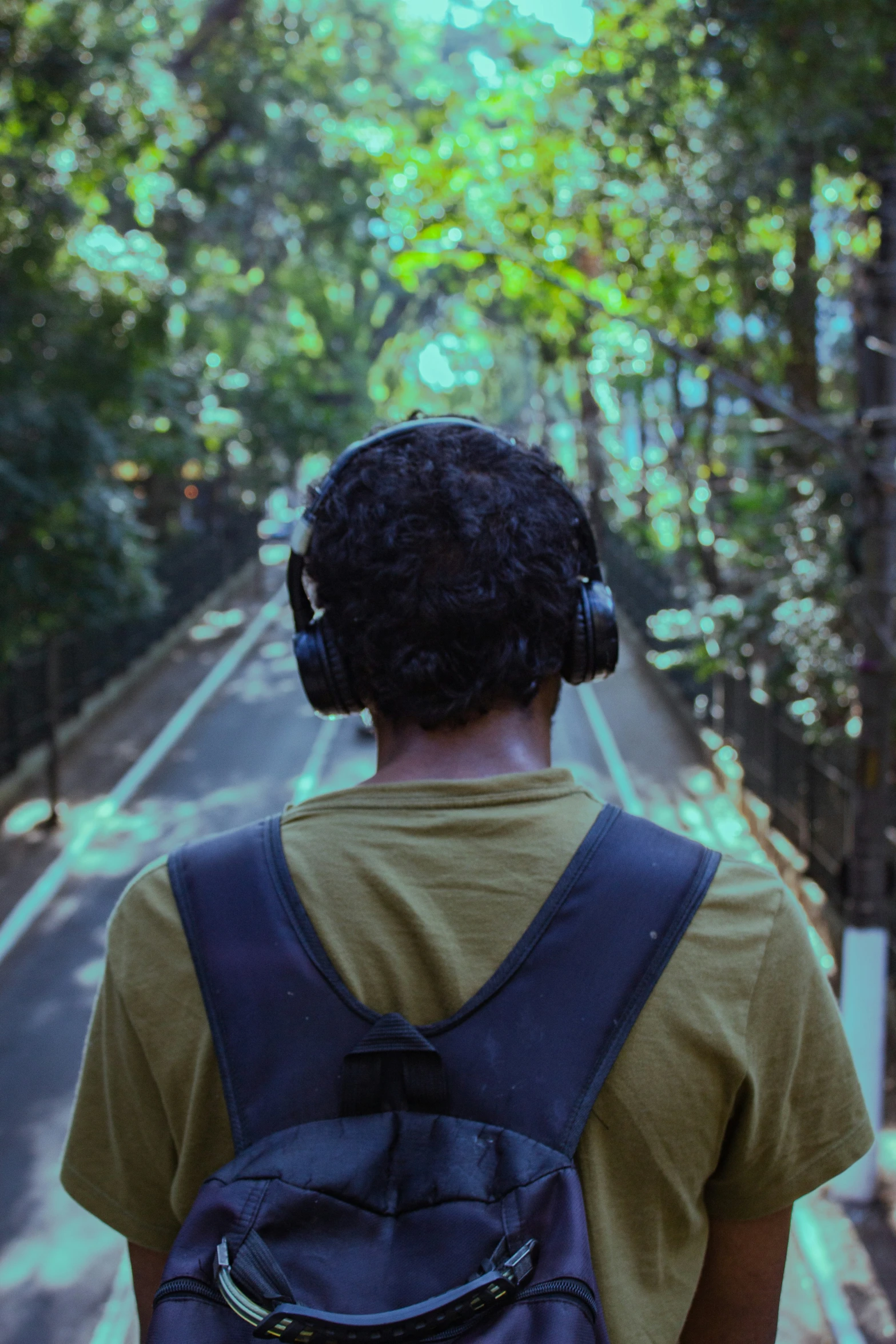 man with earphones walks on the side walk