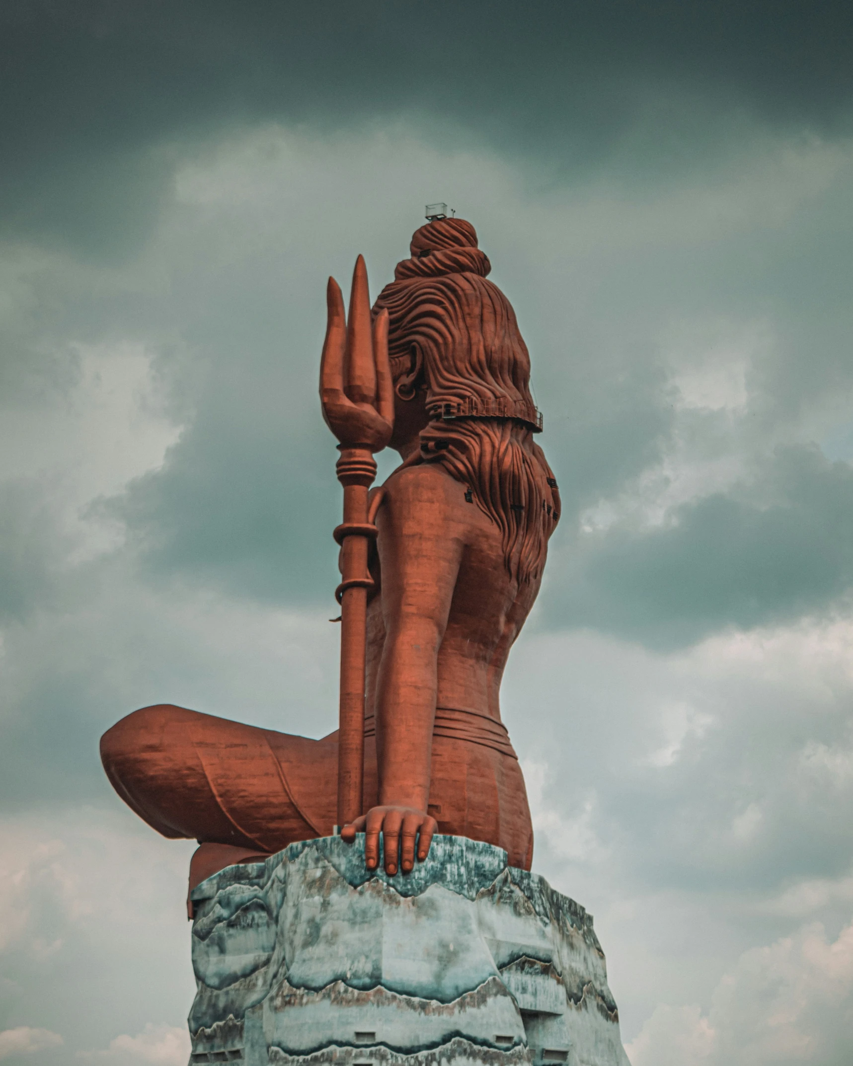 the large statue is standing in front of a cloudy sky