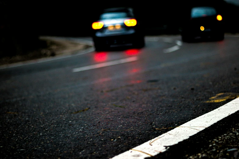 cars drive on the side of an open road at night