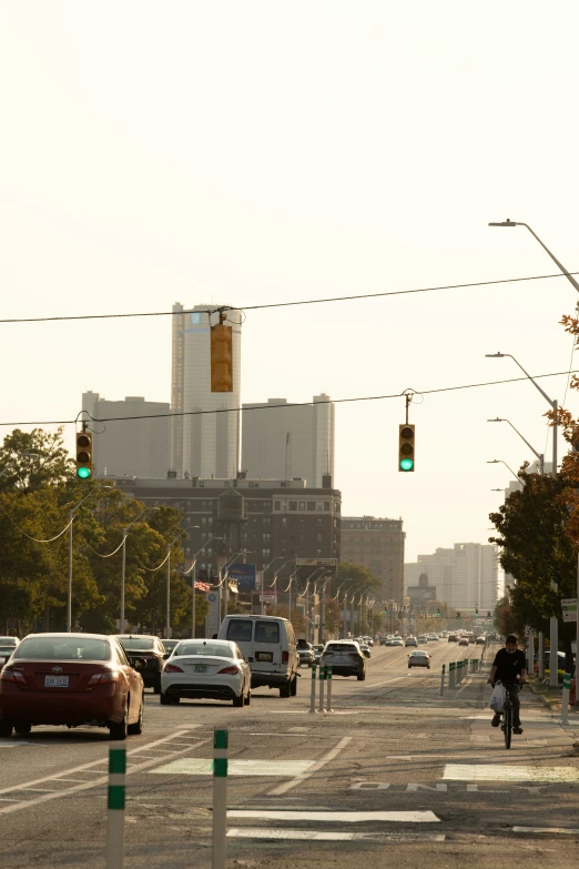 a man riding a bike across a crosswalk near some cars