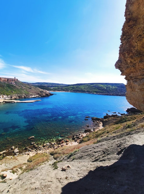 the water is blue and clear with lots of green on the mountain