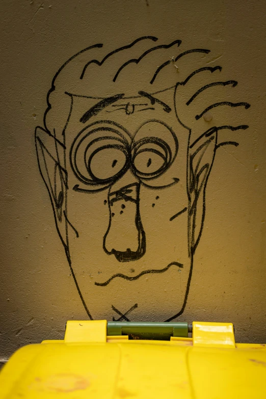 there is graffiti on the side of a wall of a man with glasses