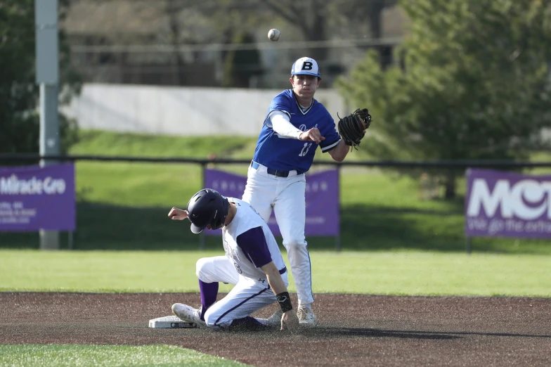 two baseball players, one with his arm raised above the other