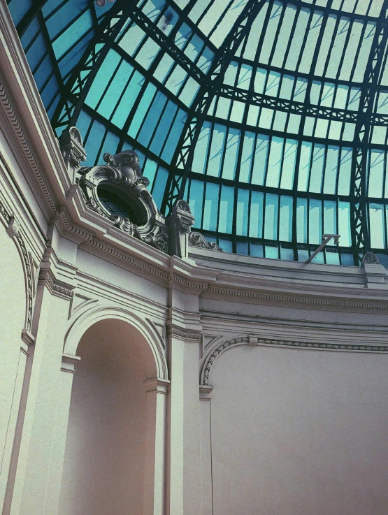 a clock mounted to the side of a glass roof