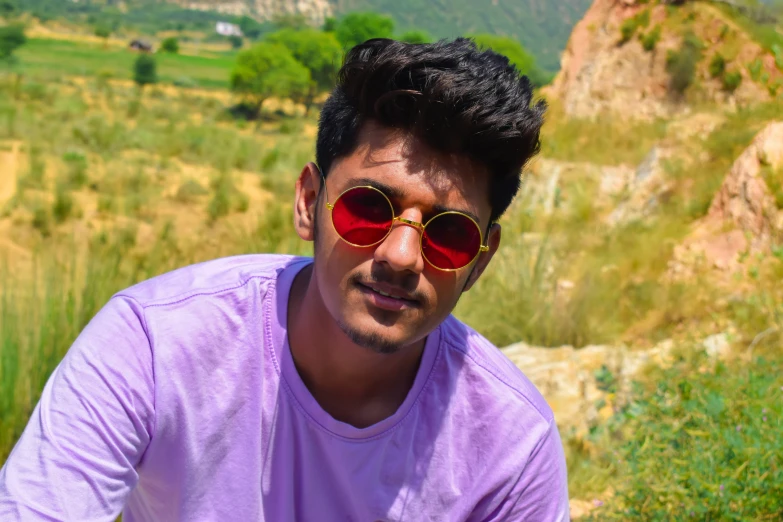 a man in a purple shirt and red sunglasses