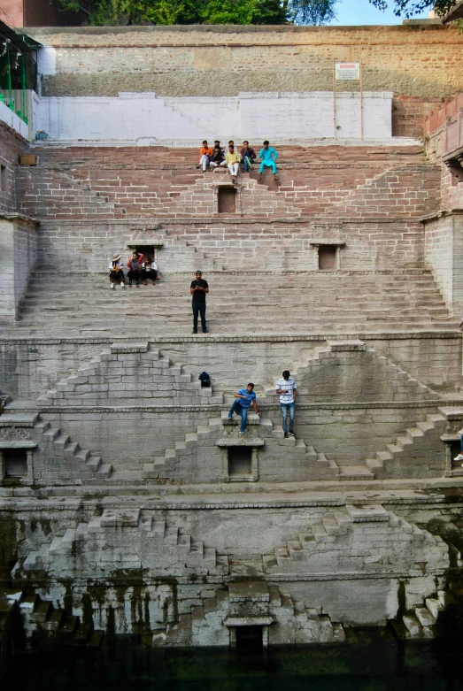 a group of people sitting on top of some stone steps