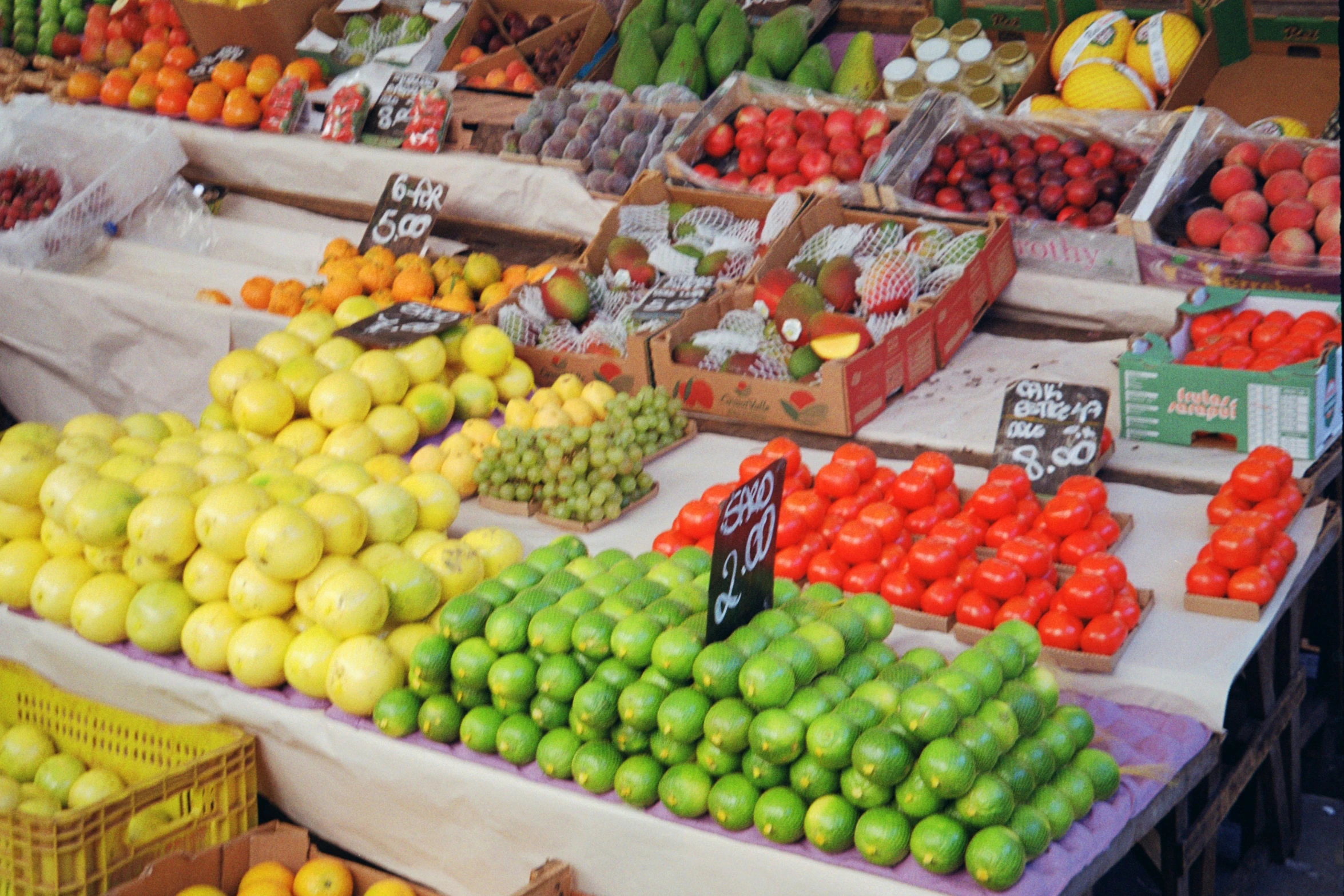 a produce stand with many fruits and vegetables in boxes