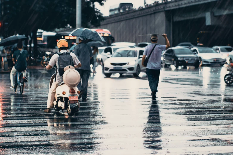 people walking and riding in the rain with umbrellas