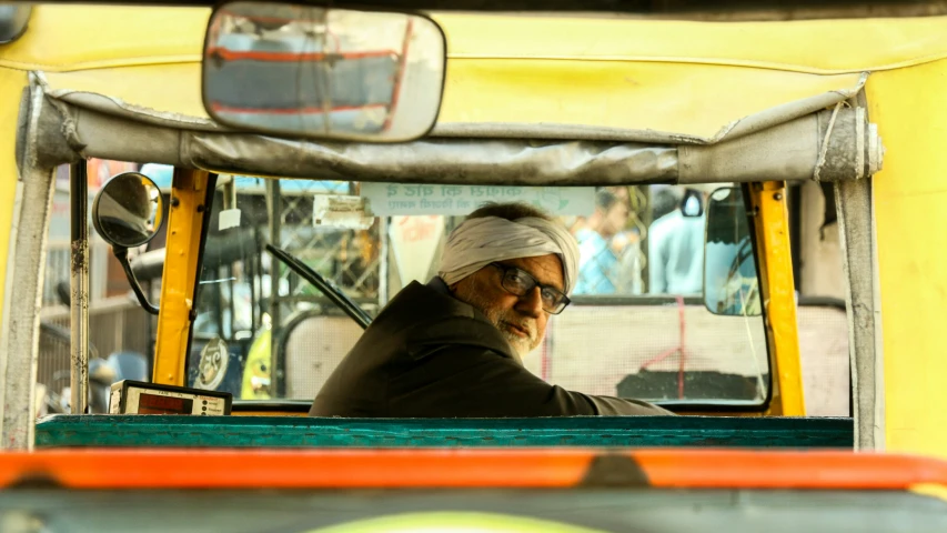 a man wearing a blindfold driving on a bus