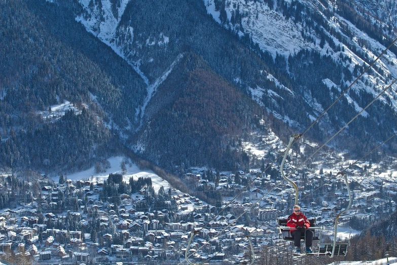 a couple of men riding skis on top of a snow covered slope