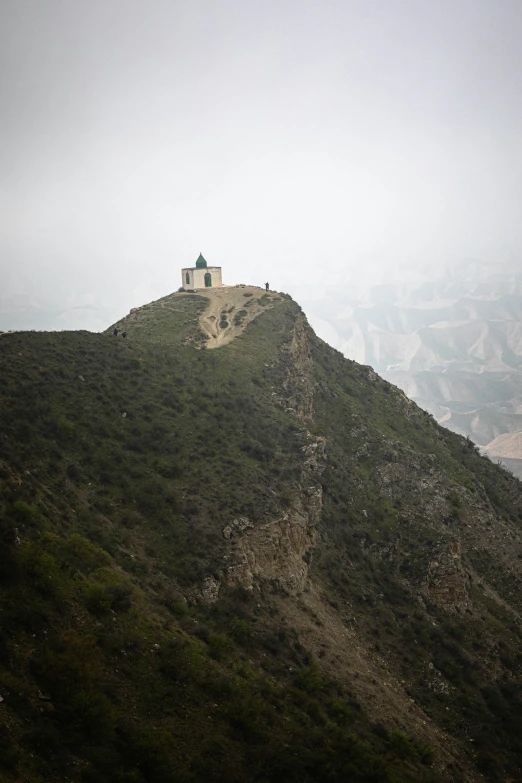 a small church on a hill top in the mountains