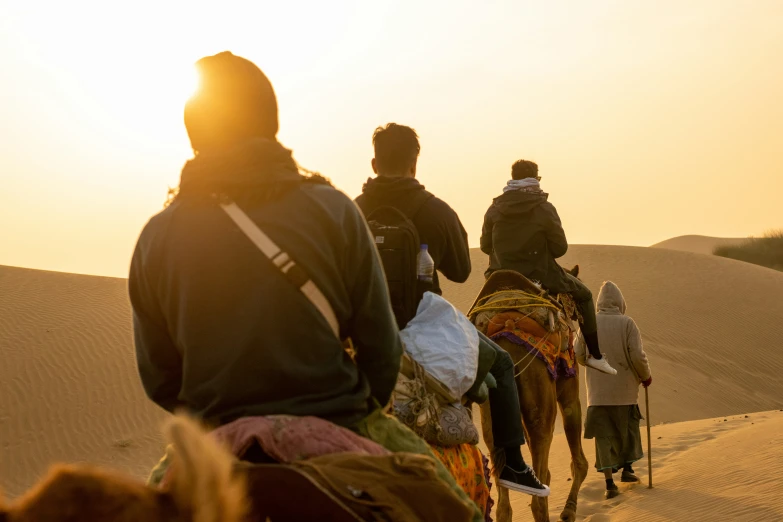 a group of people riding horses through the desert