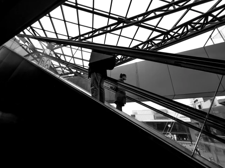 man on escalator in city holding umbrella