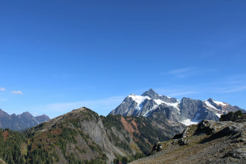 three large mountain peaks that are surrounded by trees