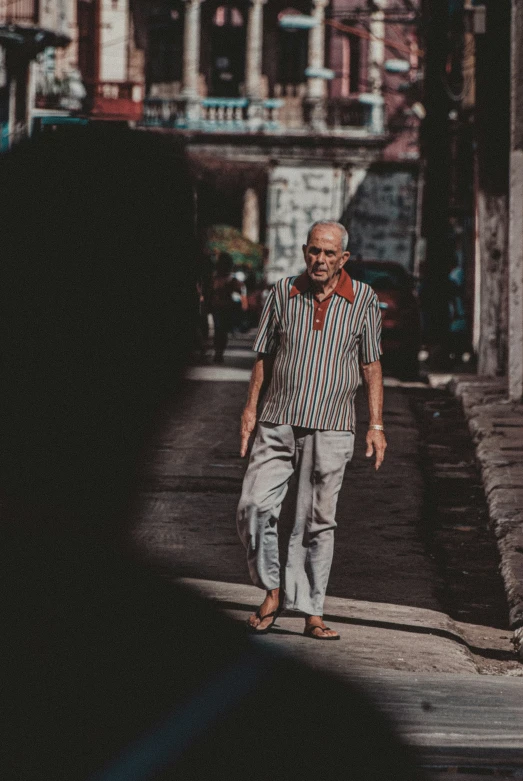 a man walks down a street in the middle of the daytime