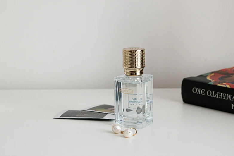 a white bottle on a counter near two books