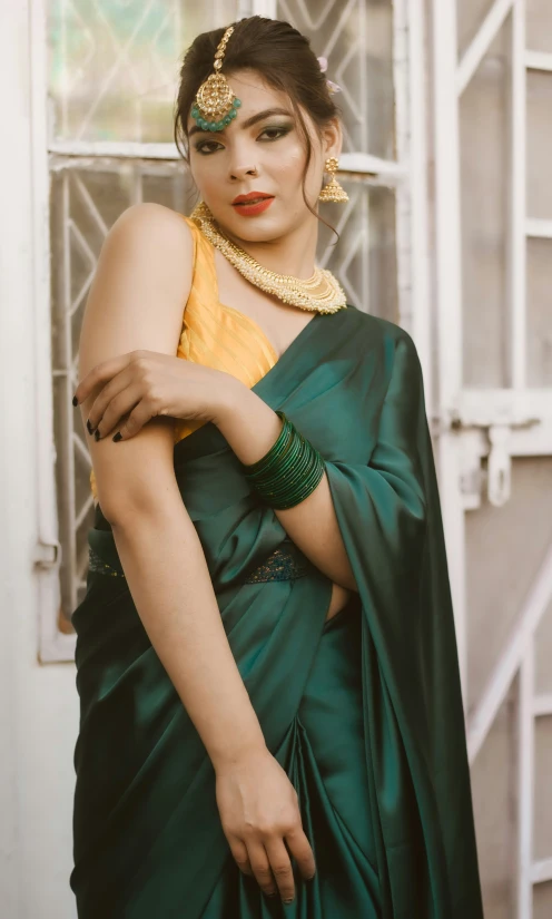 woman in traditional indian garb standing with hands crossed